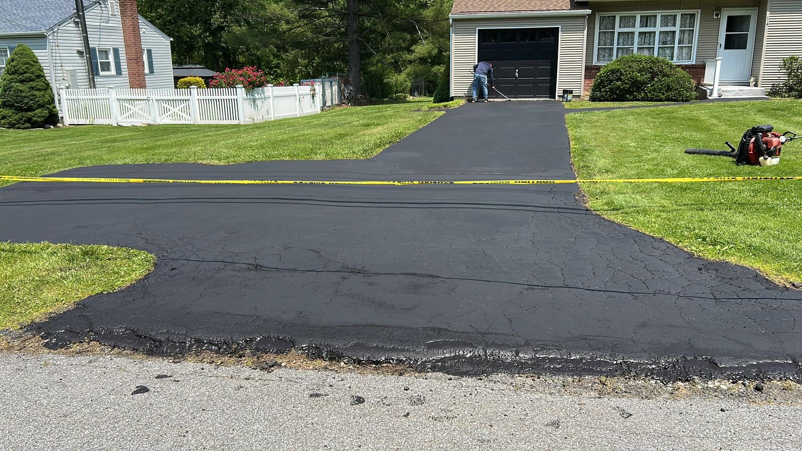 Blacktop driveway being sealcoated